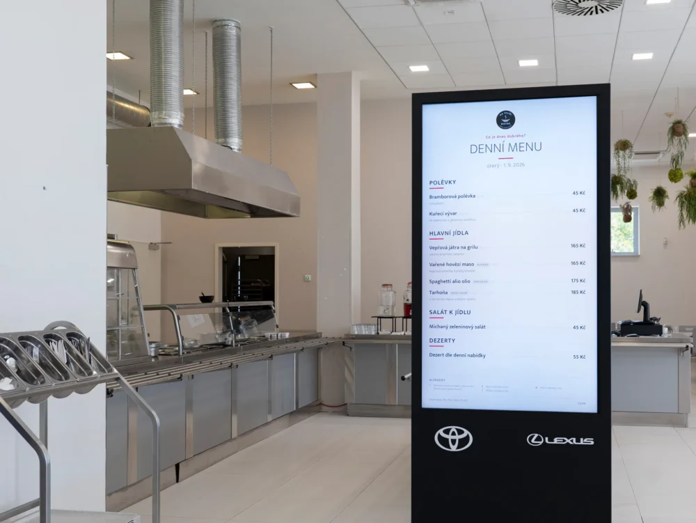 Výdejní linka bistra a stojan s obrazovkou, na které svítí denní menu
