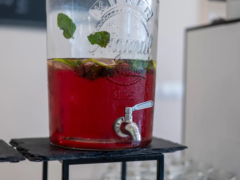 Detail skleněného barelu s domácí ovocnou limonádou a lístky máty