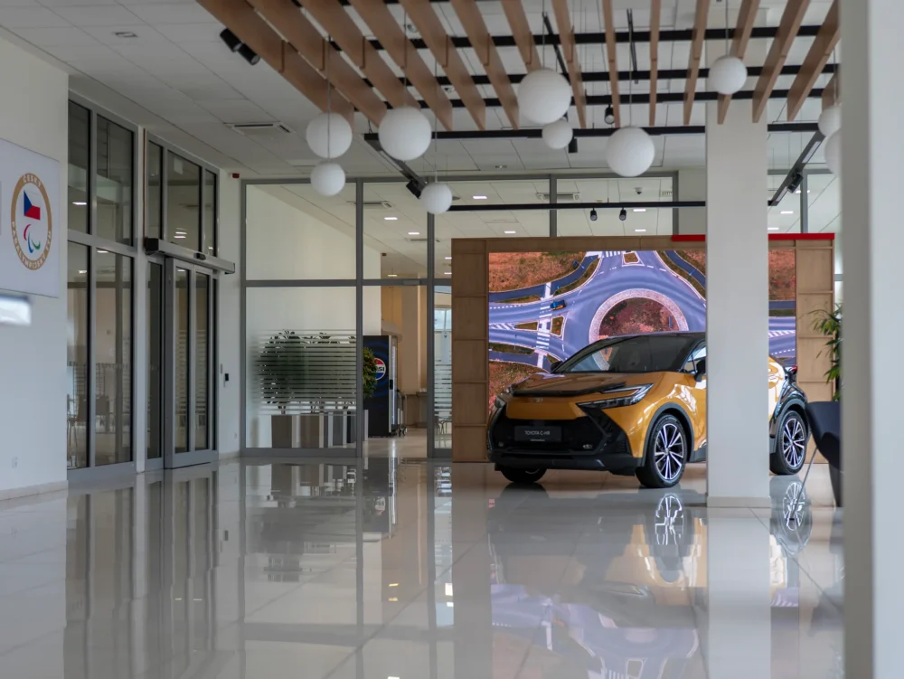 Prosklená vstupní hala budovy s vystaveným vozem Toyota